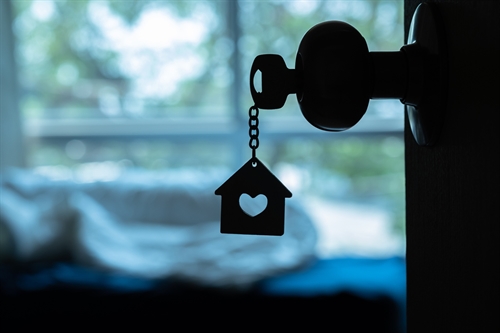 A key fob shaped like a house with a heart in the middle.