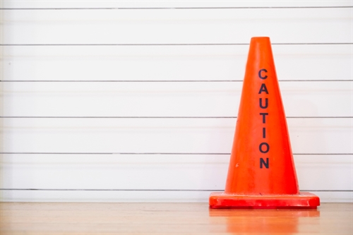 bright orange traffic cone with the word caution on it.