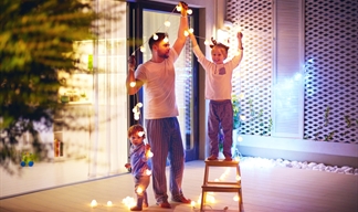 Dad and two boys taking down Christmas lights in a large modern room Dad and two boys taking down Christmas lights in a large modern room
