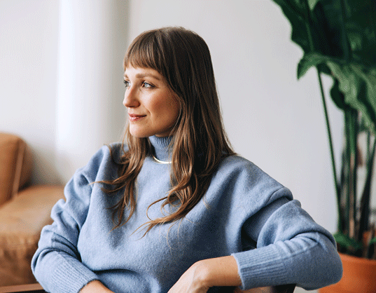 Woman sitting looking peaceful knowing she is insured for her content insurance at her storage unit